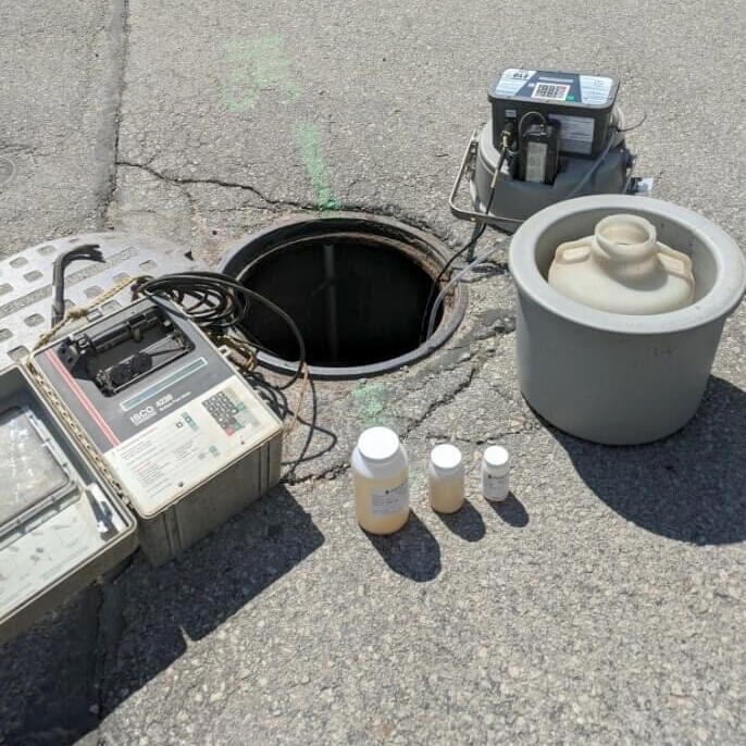 Field Sampling & Monitoring - Open Manhole Cover with Testing Equipment